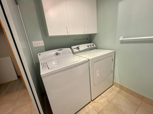 a white washer and dryer in a small room at Le Chalet Bleu, aux pieds des Monts-Valin in Saint-David-de-Falardeau