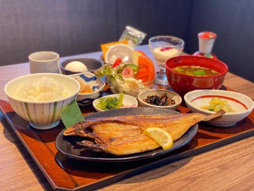 Henn na Hotel Komatsu Ekimae في كوماتسو: طاولة مع طبق من الطعام وأوعية من الطعام