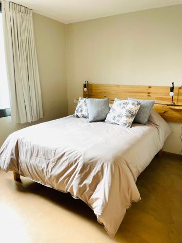 Un dormitorio con una cama grande con almohadas. en Casa Champagnat, en Mendoza