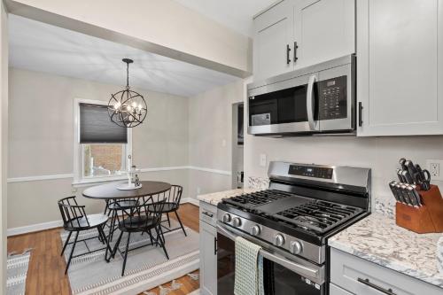 a kitchen with a stove and a table with chairs at Isla's Landing in Lexington