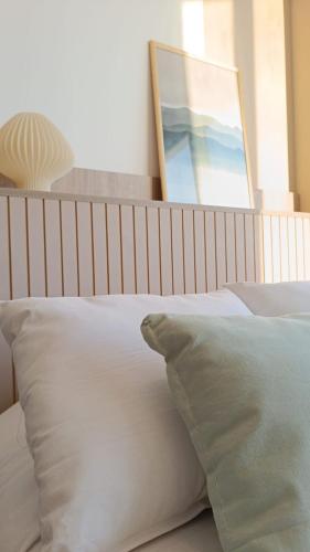 a bed with a white pillow and a picture at Monoambiente ACACIAS I in Cipolletti