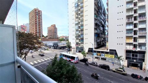 un autobús conduciendo por una calle de la ciudad con edificios altos en Departamento 2 ambientes en zona Güemes con balcón a la calle a 1 cuadra del Mar en Mar del Plata