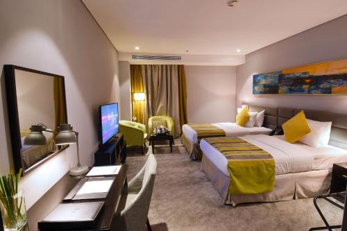 a hotel room with two beds and a flat screen tv at Best Western Plus Fursan in Riyadh