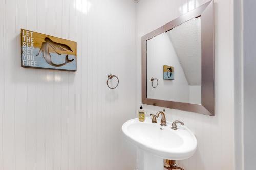 a white bathroom with a sink and a mirror at Springwood Villas 51 in Hilton Head Island