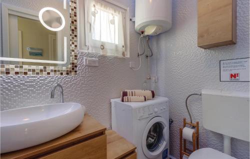a bathroom with a washing machine and a sink at Amazing Home In Nerezine With Outdoor Swimming Pool in Nerezine