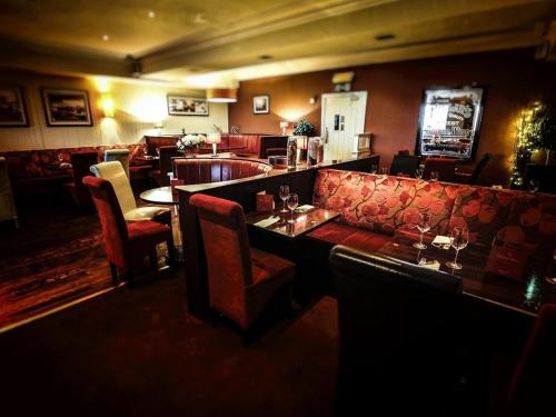 a restaurant with a couch and tables and chairs at Customs House Country Inn in Belcoo