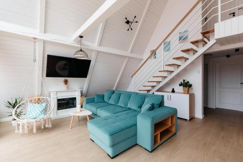 salon z niebieską kanapą i schodami w obiekcie Black & White Panoramic w mieście Rimetea