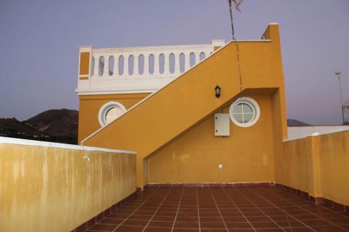 a yellow building with a staircase on top of it at Villa Granada Motril in Motril