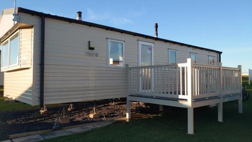 a mobile home with a porch and a deck at Your Holidays in Scotland. in Eyemouth