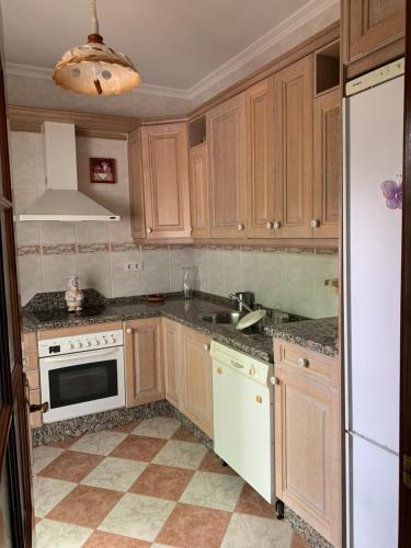 a kitchen with wooden cabinets and a white appliance at Al ladito de Sevilla in Bormujos
