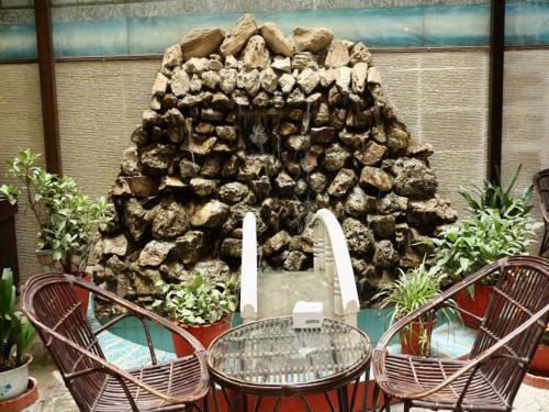 a stone wall with a table and four chairs at Hotel Pleasure Home in Kathmandu
