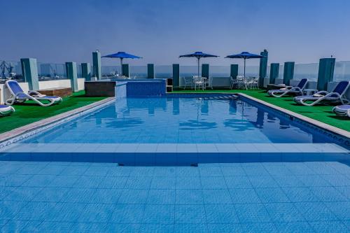 a swimming pool on top of a building with chairs and umbrellas at Hotel Mar y Tierra in Veracruz