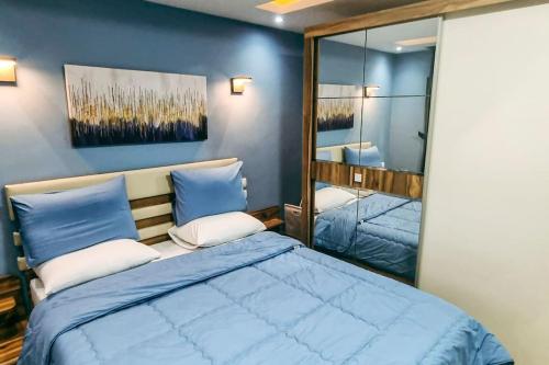 a bedroom with a large blue bed with a mirror at Luxury VIP apartment in Cairo