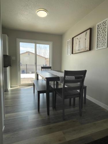 a dining room with a table and chairs and a window at Ray's Place in Roy