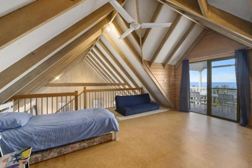 a bedroom with a bed and a large window at Blue Oar Beach House Arrawarra Headland in Arrawarra