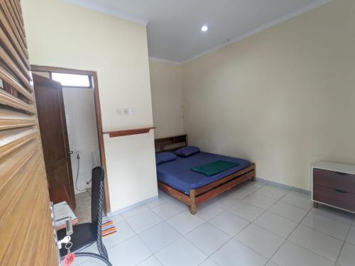 een kleine kamer met een bed in de hoek bij Rumah Pagar Merah Homestay in Yogyakarta