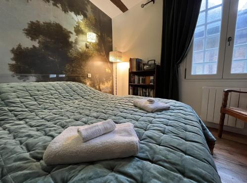 1 dormitorio con 1 cama grande y 2 toallas. en Le refuge d'Henriette - Vannes, en Vannes