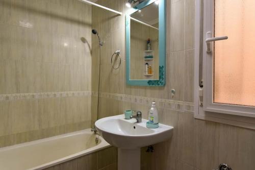 ein Badezimmer mit einem Waschbecken, einem Spiegel und einer Badewanne in der Unterkunft Apartamento Playa Grande in Los Abrigos