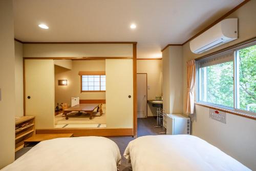 a bedroom with two beds and a mirror at Shorenkan Yoshinoya in Kyotango