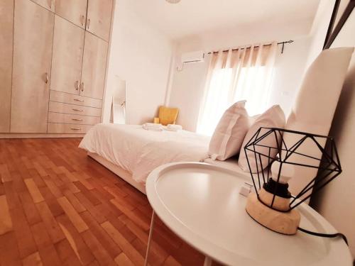 um quarto branco com uma cama e uma mesa em Lovely 2-Bedroom 4th Floor House Large Patio em Atenas