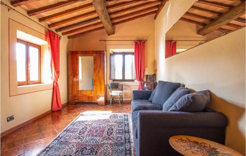 a living room with a blue couch and red curtains at Lovely Apartment In Volterra With Wifi in Volterra