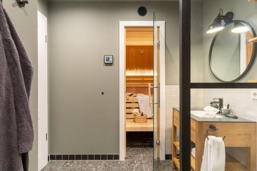 ein Bad mit einem Waschbecken und einem Spiegel in der Unterkunft Appartmenthaus "Südstrand 44", Wohnung 15 "Abendrot" in Großenbrode