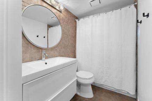 bagno bianco con lavandino e specchio di Staycation in West Los Angeles a Los Angeles