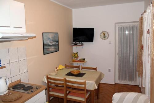 een keuken en eetkamer met een tafel en stoelen bij Apartments by the sea Brodarica, Sibenik - 20762 in Šibenik
