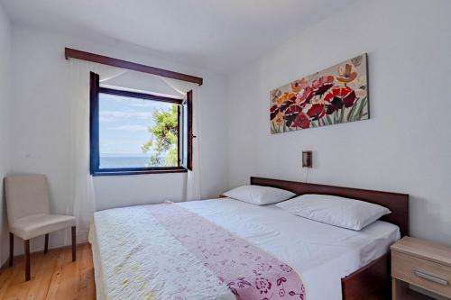ein kleines Schlafzimmer mit einem Bett und einem Fenster in der Unterkunft Apartments by the sea Prigradica, Korcula - 20871 in Blato