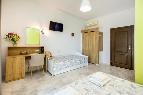 a room with a bed and a desk and a table at Marti Resort in Skala Sotiros
