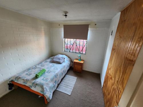 a small bedroom with a bed and a window at Concepción - San Pedro de la Paz in San Pedro de la Paz