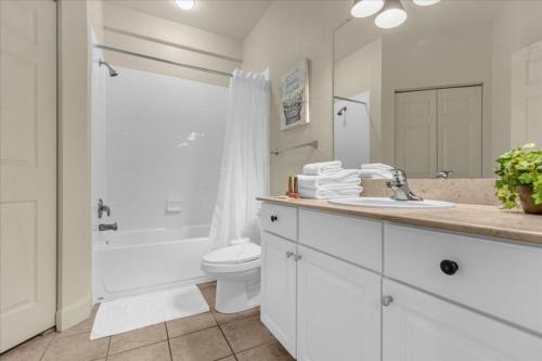 Baño blanco con lavabo y aseo en 4 Bedrooms- 3 Bathrooms Lucaya Village 9-104 Lv, en Kissimmee