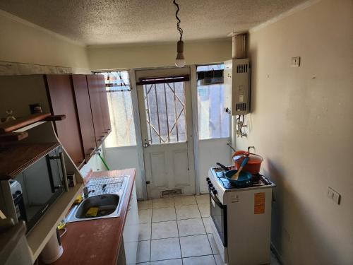 a small kitchen with a stove and a sink at Concepción - San Pedro de la Paz in San Pedro de la Paz