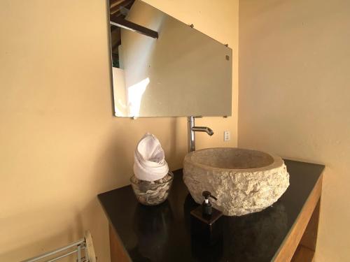 y baño con lavabo de piedra y espejo. en Villa Light - Amed Bali, en Amed