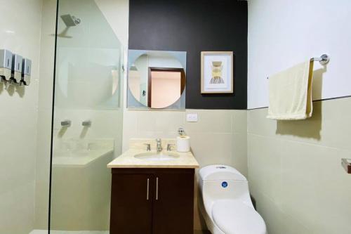 een badkamer met een wastafel, een toilet en een spiegel bij Lujo Frente al Mar Morros Cartagena in Cartagena