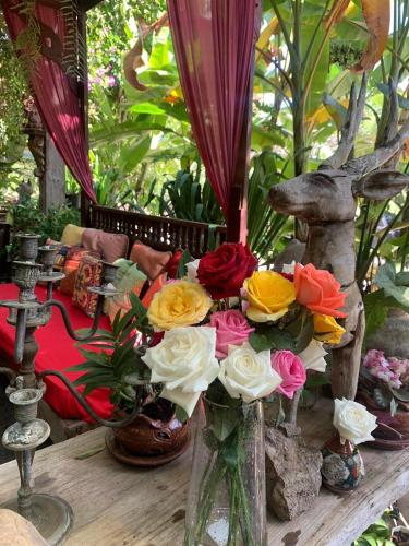 Un jarrón lleno de flores de colores sobre una mesa. en Hongkhao Village, en Chiang Mai