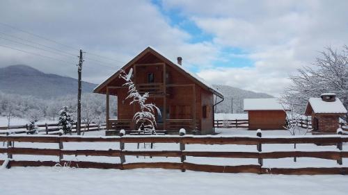 a cabin in the snow with a fence at Chalet Sanjam Liku in Bužim
