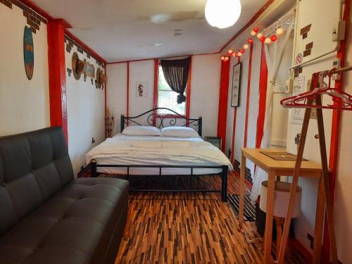 1 dormitorio con cama y sofá en ThaiMex Cafe & Homestay Backpackers- Adults Only, en Prachuap Khiri Khan