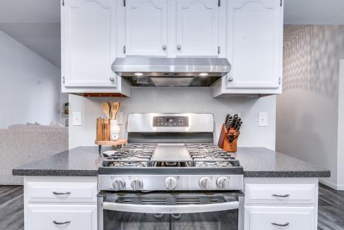 a kitchen with a stove and white cabinets at New! Modern • Family Friendly • The Desert Nest in Sierra Vista