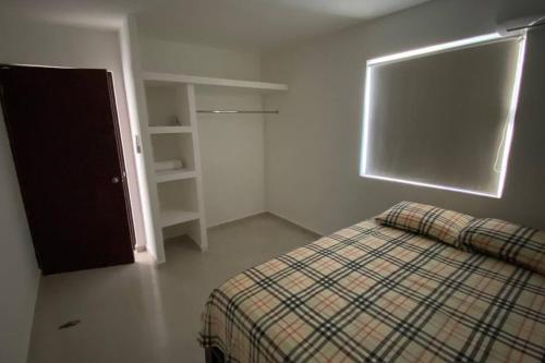 um pequeno quarto com uma cama e uma janela em Moderno Departamento Paseo la Cortadura en Tampico em Tampico