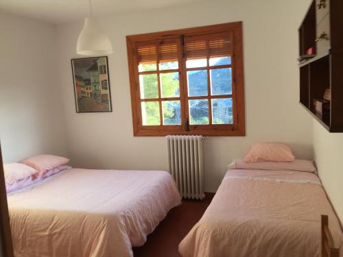 dwa łóżka w pokoju z oknem w obiekcie El Huerto de Maravillas w mieście Cehegín