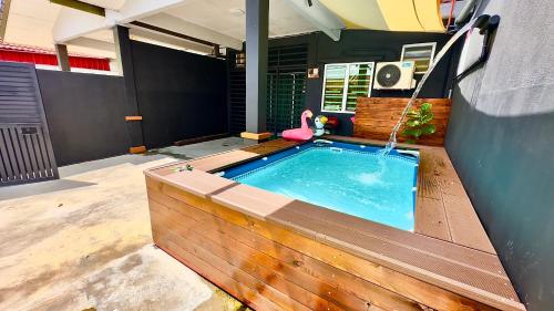 a swimming pool in a house with a pink flamingo at Eisya Guest House With Pool in Arau