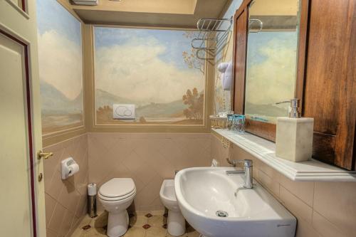 a bathroom with a sink and a toilet and a window at L'antica Bifore in Lucca