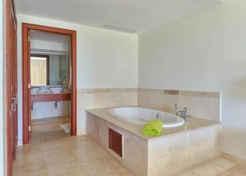 a large bathroom with a tub and a sink at Relax Beach Condo W Private Pool And Beach! in Punta Cana