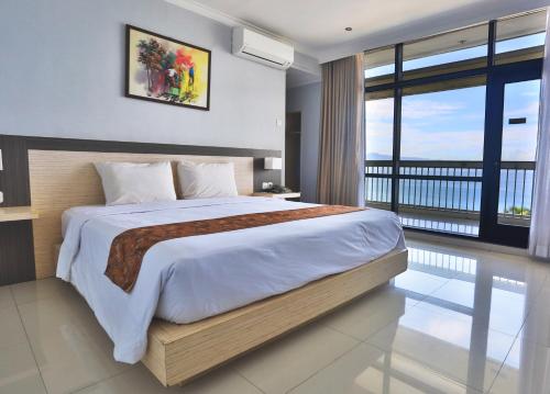 a bedroom with a large bed and a balcony at Grand Inna Samudra Beach in Cimaja