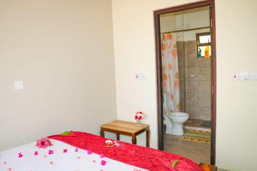 a bedroom with a bed and a bathroom with a toilet at RedFin Vacation Home in Vipingo
