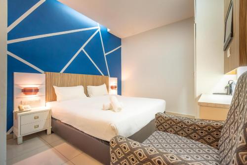a bedroom with a large bed with a blue wall at Swing & Pillows - Subang SS15 in Subang Jaya
