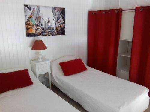 - une chambre avec 2 lits et un rideau rouge dans l'établissement Studio moderne avec mezzanine et parking proche plage - FR-1-338-314, à Sète