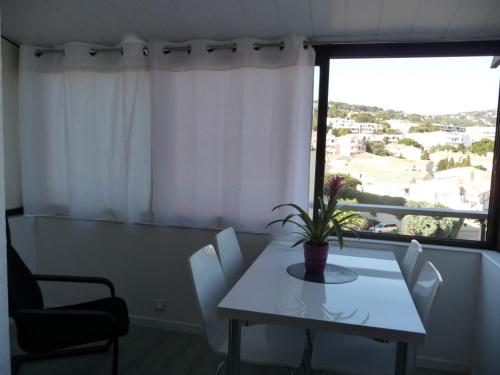 une salle à manger avec une table et des chaises et une fenêtre dans l'établissement Studio moderne avec mezzanine et parking proche plage - FR-1-338-314, à Sète