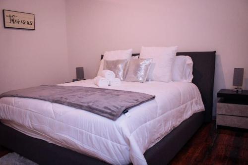 a bedroom with a large bed with white sheets and pillows at Cozy Stylish Downtown Loft in Saint Louis